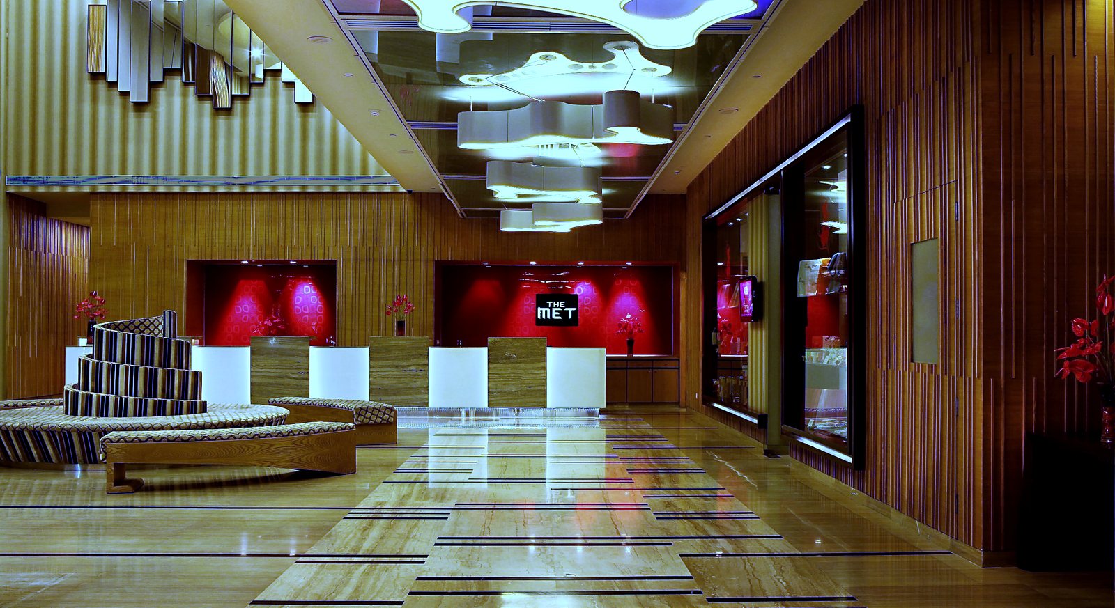The reception desk, lit against its red panel